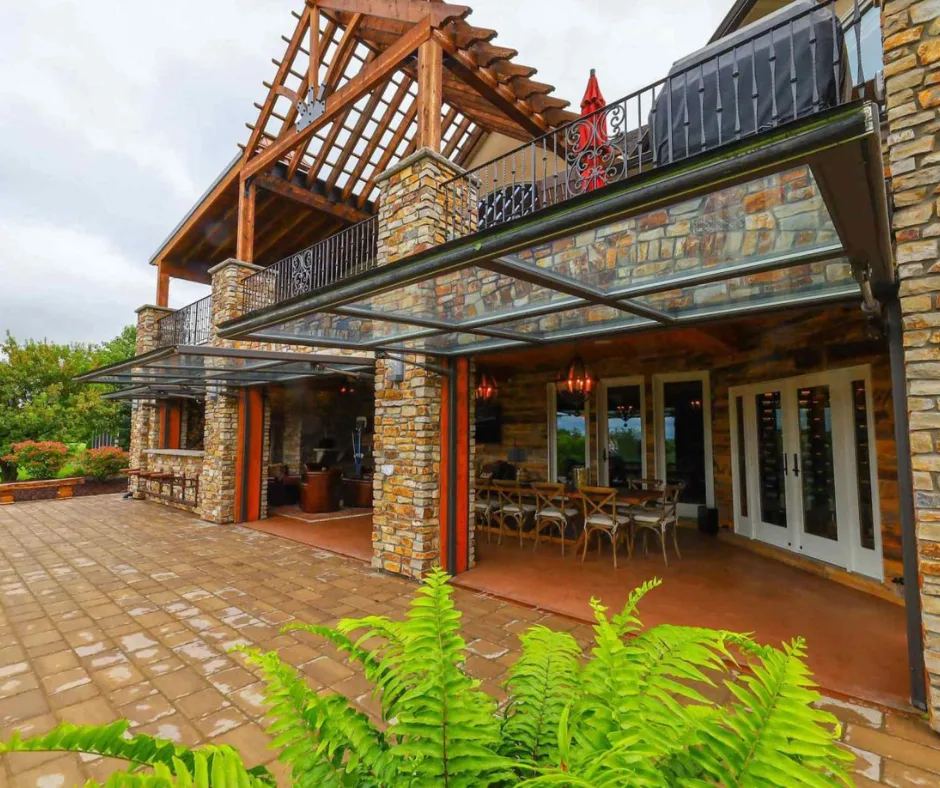Glass hydraulic doors raised over a stone patio